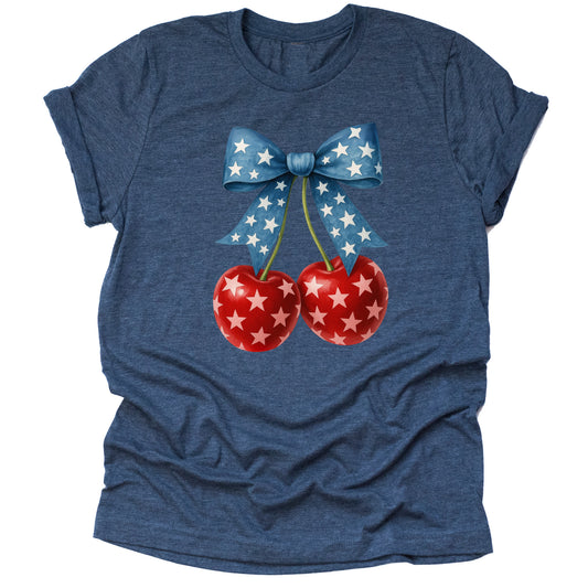 A casual short-sleeve unisex T-shirt in a light color, featuring a design of two red cherries with a stars pattern, tied with a blue ribbon with stars, celebrating a patriotic theme.