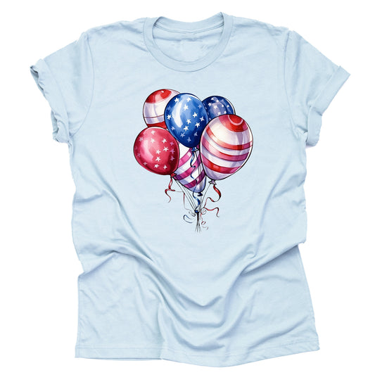 A casual short-sleeve unisex T-shirt in a light blue color, featuring a design of red, white, and blue balloons with stars and stripes, reminiscent of the American flag.