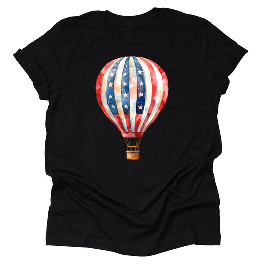 A black unisex T-shirt featuring a vibrant graphic of a hot air balloon with a American flag theme, with stars and stripes in red, white, and blue colors.